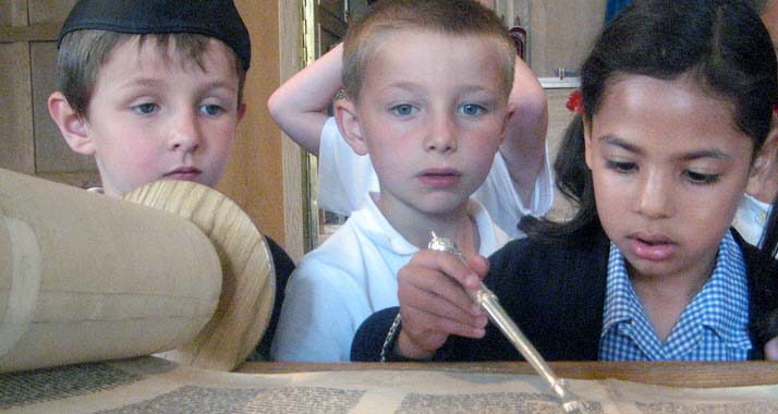 Jüdische Kinder lesen in einer Torahrolle.
