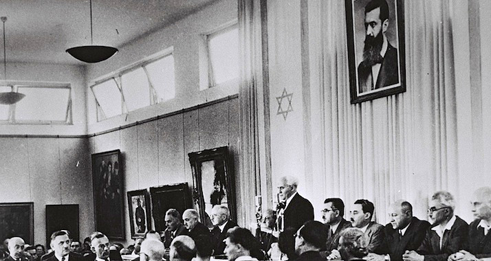 David Ben-Gurion verliest im Stadtmuseum von Tel Aviv die israelische Unabhängigkeitserklärung – über ihm hängt ein Portrait von Theodor Herzl, der als Begründer des modernen Zionismus gilt.