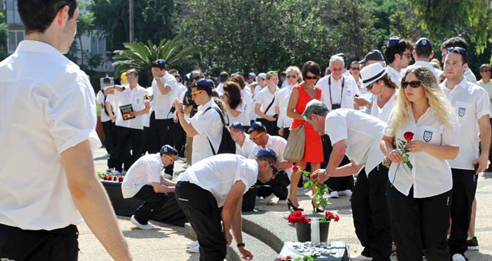 Die Teilnehmer der deutschen Sport-Delegation legen rote Rosen an der Gedenkstätte für das Attentat von München nieder.