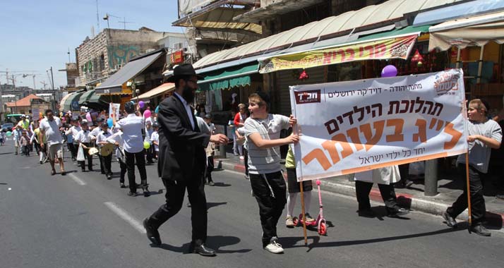 Mit Trommel und Transparent: Die Prozession zum Fest "Lag Ba'Omer" bahnt sich ihren Weg.