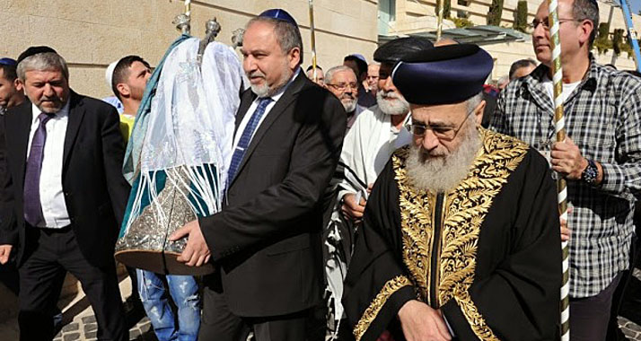 Lieberman trägt die restaurierte Torah durch das Außenministerium.