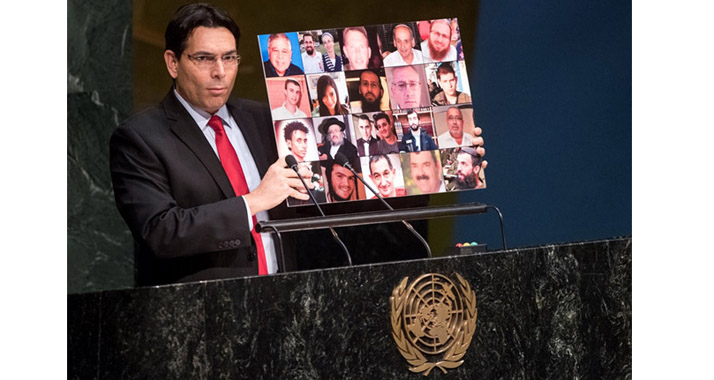 Danny Danon hielt während seiner Rede vor den UN ein Poster hoch, das getötete Israelis zeigt