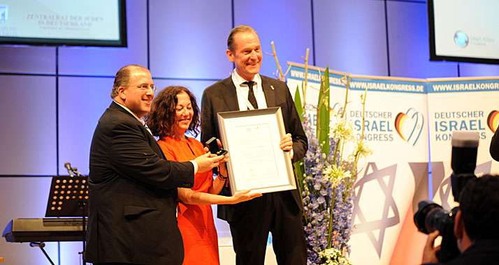 Kongressveranstalter Sacha Stawski (l.) und Gila Lustiger überreichen die Urkunde an Mathias Döpfner