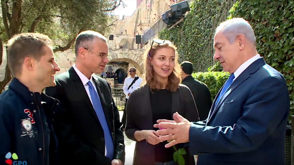 Der rumänische Tourist Mihai Georgescu, der israelische Tourismusminister Jariv Levin und die rumänische Touristin Ioana Isac hören dem israelischen Premierminister Benjamin Netanjahu in Jerusalem zu