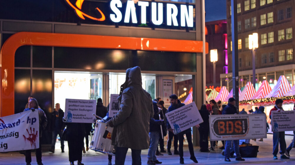 Die Trommel des BDS-Demonstranten verhallt auf dem Berliner Alexanderplatz vor dem Elektrogeschäft Saturn