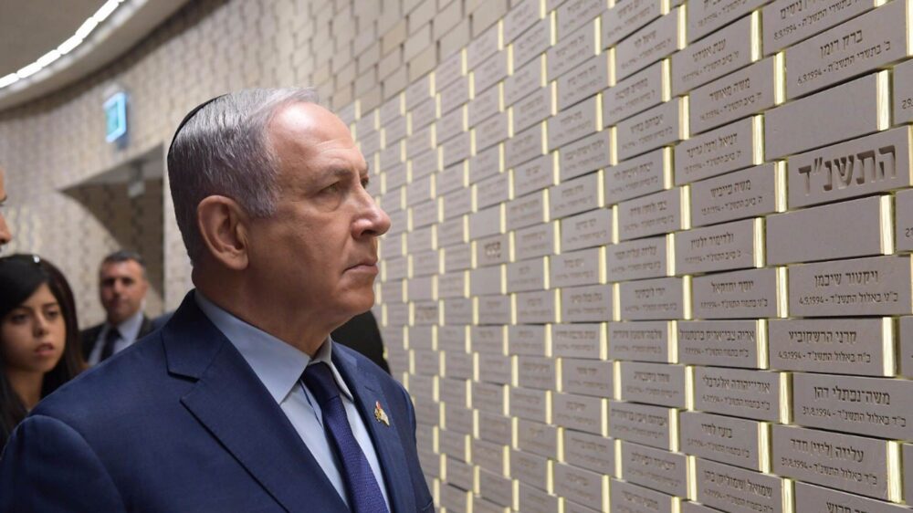 Netanjahu betrachtet die Ziegel in der Gedenkhalle mit den Namen der Gefallenen und Terror-Opfer