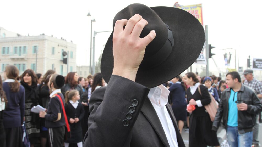 Ultra-orthodoxe Männer tragen schwarze Anzüge und Hüte. Dadurch bringen sie ihre konservative Einstellung und die Abschottung gegenüber der übrigen Welt zum Ausdruck.