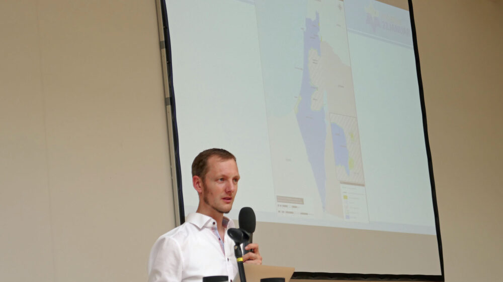 Referent Josias Terschüren vor einer Landkarte – sie zeigt die Waffenstillstandslinien zwischen Israel und den arabischen Ländern nach dem Unabhängigkeitskrieg, der 1949 endete