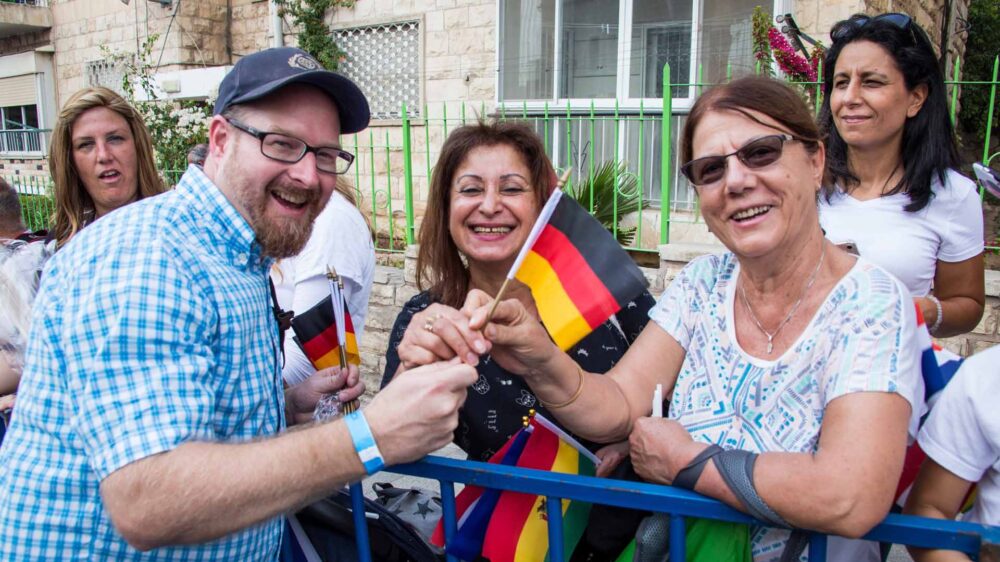 Stephan Lehnert, Büroleiter der ICEJ-Deutschland, verteilt deutsche Fähnchen an israelische Zuschauer beim Jerusalem-Marsch