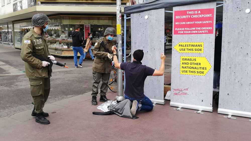 Als israelische Soldaten verkleidet inszenieren BDS-Anhänger „menschenunwürdige Behandlung“ an einer nachgebauten Checkpoint-Mauer