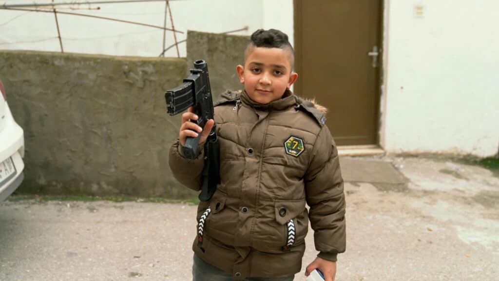 Ein Kind im Flüchtlingslager von Dschenin spielt mit einer aussortierten Waffe.