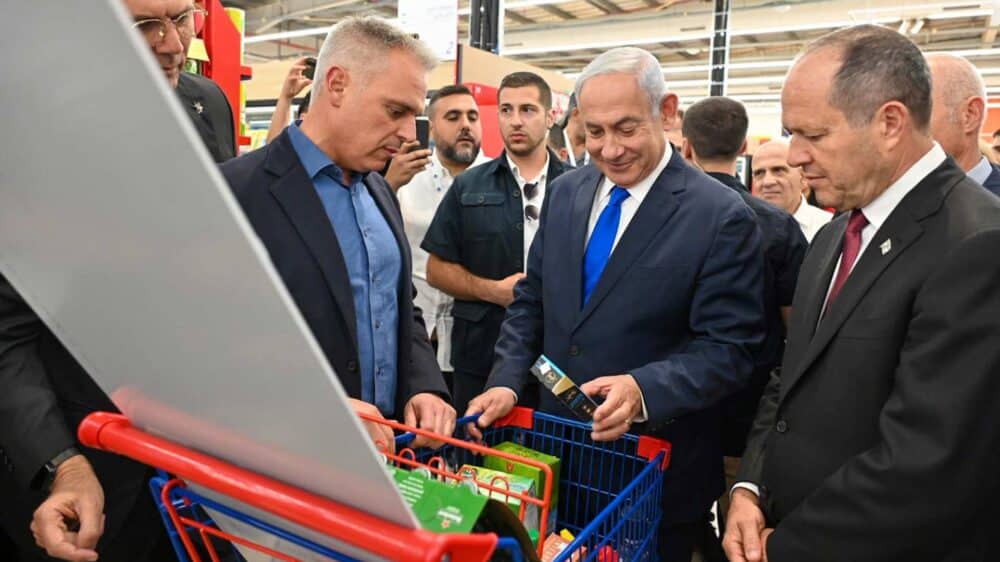 Der israelische Premier Netanjahu (M.) und Wirtschaftsminister Barkat (r.) bei der Eröffnung einer Carrefour-Supermarktes