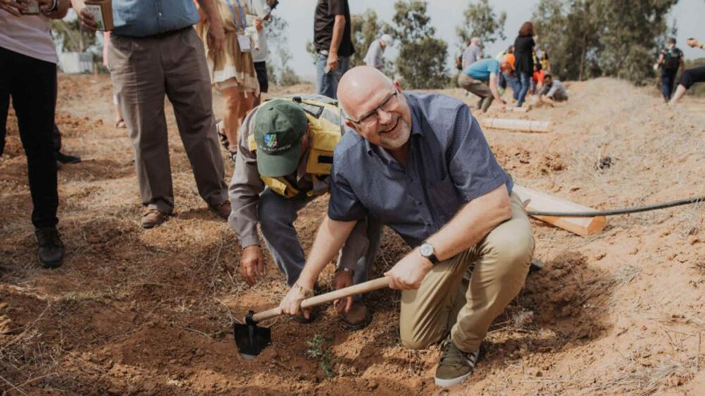 Der Präsident der ICEJ, Bühler, hilft mit beim Einpflanzen der Bäume